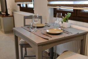 a table with two plates and wine glasses on it at Everlong Boutique Home in Nea Michaniona