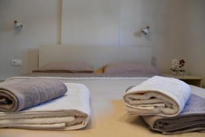 a room with two beds with towels on them at Everlong Boutique Home in Nea Michaniona