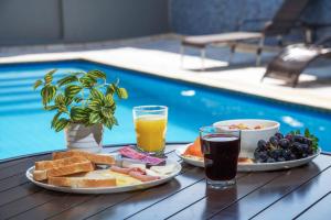 a table with breakfast foods and drinks next to a pool at Hotel Dan Inn Express Ribeirão Preto By Nacional Inn in Ribeirão Preto