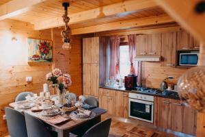 a kitchen and dining room with a table and chairs at Turističko naselje MOSLAVAČKA DOLINA by Irundo in Velika Ludina +36 photos