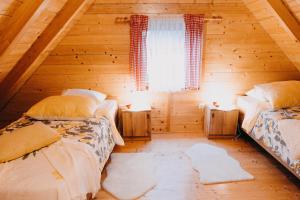 a bedroom with two beds in a wooden cabin at Turističko naselje MOSLAVAČKA DOLINA by Irundo in Velika Ludina