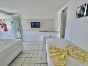 a bedroom with a bed with a yellow bow on it at Pousada e Hostel Natal in Natal