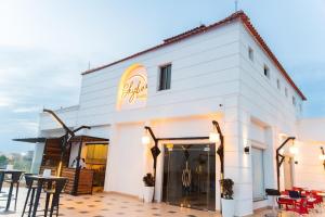 a white building with a restaurant with tables and chairs at Bissau Royal Hotel in Bissau