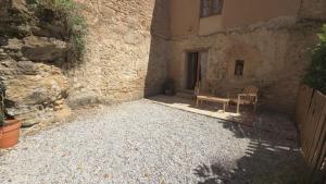 a stone building with a chair and a window at L'Hirondelle in Airvault