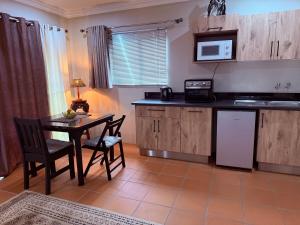 a kitchen with a table and chairs and a microwave at Pringle Studio in Benoni