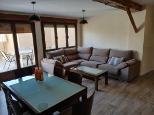 a living room with a couch and a table at Casa del Portón - Housevanlive in Casas Altas
