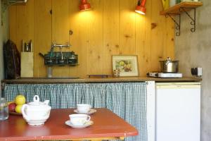 a kitchen with a table with bowls and cups on it at Le Presbytère de Bugarach in Bugarach +52 photos