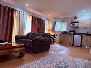 a living room with a chair and a kitchen at Pringle Studio in Benoni