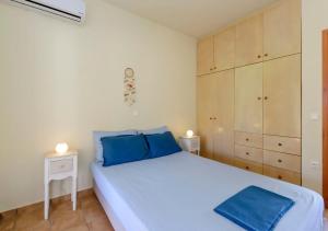 a bedroom with a large white bed with blue pillows at Seaside Aqua Bliss & Serenity with Private Pool in Kranidi +37 photos