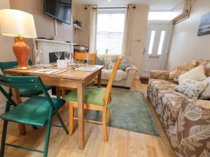 a living room with a wooden table and green chairs at Hill View in Bala +15 photos