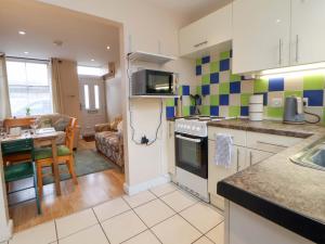 a kitchen and living room with a stove top oven at Hill View in Bala