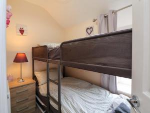 a bedroom with two bunk beds and a lamp at Hill View in Bala