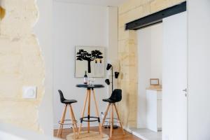 a room with two chairs and a table with a tree on the wall at Les Libournettes - Serenity in Libourne