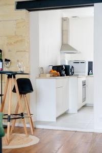 a kitchen with white cabinets and a table at Les Libournettes - Serenity in Libourne +17 photos