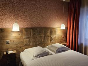 a bedroom with a large bed with two lights at Best Western Citadelle in Besançon +116 photos