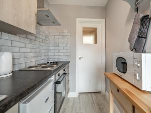 a kitchen with a counter top and a microwave at Bluebell Apartment - Uk42381 in Bridlington
