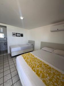 a bedroom with two beds and a bathroom at Pousada e Hostel Natal in Natal
