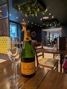 a bottle of wine and a wine glass on a table at Plato's in Kirkby Lonsdale