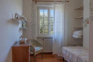 a bedroom with a bed and a window and a desk at Villa Panorama in Bardolino