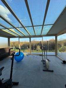 a gym with several exercise bikes in a room with windows at DAKEY home - Disneyland Paris, Village Nature in Magny-le-Hongre