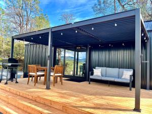 a pavilion with a table and chairs and a piano at Yosemite Chalet, Spacious Tiny Home with Mountain Views! in Coarsegold