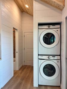a laundry room with a washer and dryer at Yosemite Chalet, Spacious Tiny Home with Mountain Views! in Coarsegold