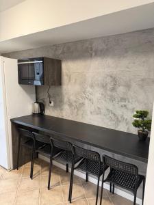 a kitchen with a black counter top and chairs at Kwatery Biała in Stara Biała