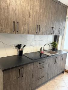 a kitchen with a sink and wooden cabinets at Kwatery Biała in Stara Biała +14 photos