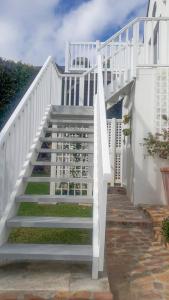 a white staircase leading up to a house at Turquoise Loft, Noordhoek, Cape Town in Good Hope +2 photos