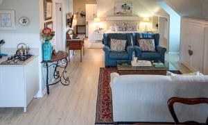 a living room with a blue couch and a kitchen at Turquoise Loft, Noordhoek, Cape Town in Good Hope