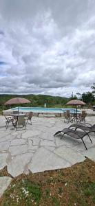 a group of chairs and umbrellas next to a pool at Chalé aconchegante, pertinho da cidade e conectada a natureza in Brasília