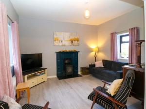 a living room with a couch and a television at Thadg and Hannahs in Milltown