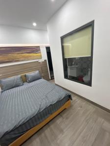 a bedroom with a bed and a large window at The rooftop villa 3 in Tây Ninh