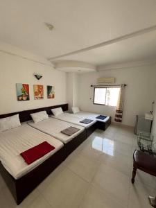 a bedroom with two beds and a television in it at Mai Guest House in Ho Chi Minh City