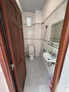 a bathroom with a toilet and a sink and a mirror at Mai Guest House in Ho Chi Minh City
