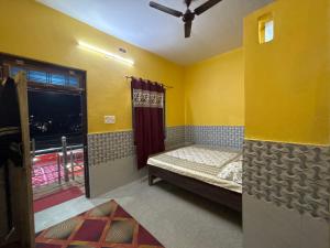 a small room with a bed and a window at Ambe hotel purnagiri in Tanakpur