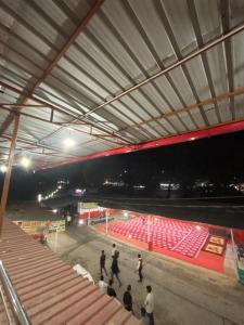 a group of people standing in a stadium at night at Ambe hotel purnagiri in Tanakpur