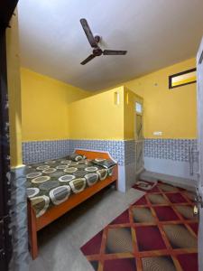 a bedroom with a bed and a ceiling fan at Ambe hotel purnagiri in Tanakpur