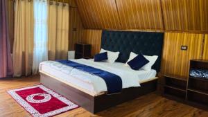 a bedroom with a large bed and a red rug at Lanying Riverview Homestay in Dirang Dzong