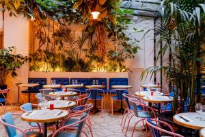 a restaurant with tables and chairs and plants at Hôtel Amour Paris in Paris