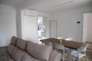 a living room with a couch and a table and chairs at Villa Serena - Luminor Apartment in Tirrenia