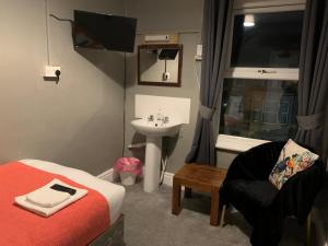 a bedroom with a bed and a sink and a chair at Coconut Cove in Blackpool