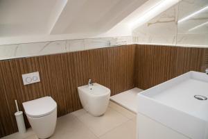 a bathroom with a white toilet and a sink at Villa Serena - Luminor Apartment in Tirrenia +7 photos