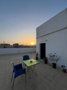 a patio with two chairs and a table on a roof at بيت جرش - Jerash House in Jerash