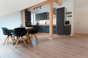 a kitchen with black cabinets and a table and chairs at SeeZeit Einruhr in Simmerath
