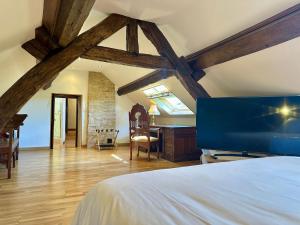 a bedroom with a bed and a desk in a room at La Floraison in Molesmes