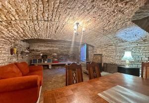 a living room with a table and a stone wall at La Floraison in Molesmes