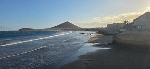 a view of a beach with a mountain in the background at Medano House Ocean Beach in El Médano