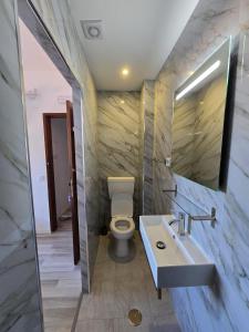 a bathroom with a toilet and a sink and a mirror at Sol da Praia in Odeceixe +8 photos