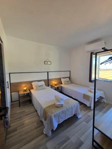 a hotel room with two beds and a window at Sol da Praia in Odeceixe